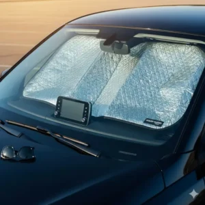 A compact, small windshield sun shade tucked neatly into a car's door-side storage pocket.