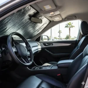 A close view of a steering wheel and seats protected from sun damage and excessive heat by a robust window heat shield car.